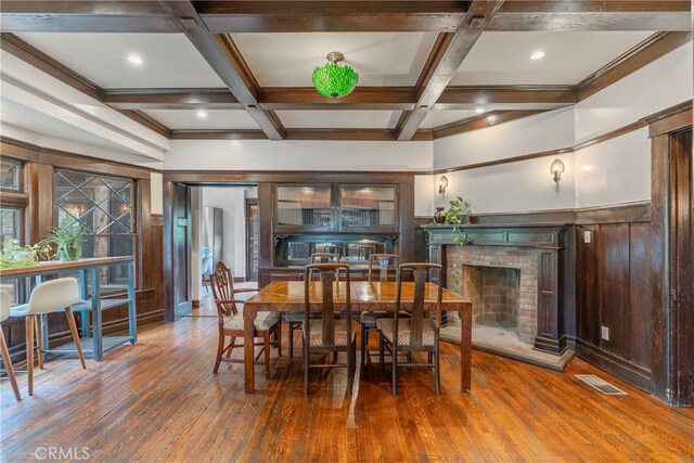 2280 W 24th St, Los Angeles, CA 90018 - dining area with coffered ceiling, wood finished floors, a brick fireplace, visible vents, and beamed ceiling