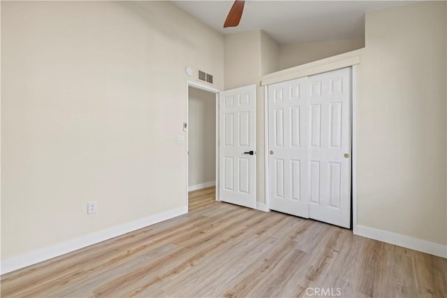 unfurnished bedroom with a closet, wood finished floors, baseboards, visible vents, and ceiling fan