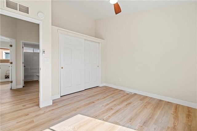 unfurnished bedroom featuring light wood-type flooring, a closet, baseboards, and visible vents