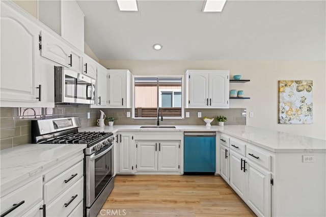 kitchen featuring white cabinetry, open shelves, a sink, and stainless steel appliances