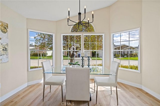 dining space featuring light wood-style flooring, a chandelier, and plenty of natural light