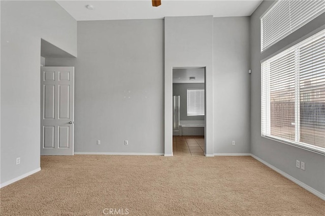 13204 Monrovia St, Hesperia, CA 92344 - unfurnished bedroom with baseboards, carpet flooring, a high ceiling, and multiple windows
