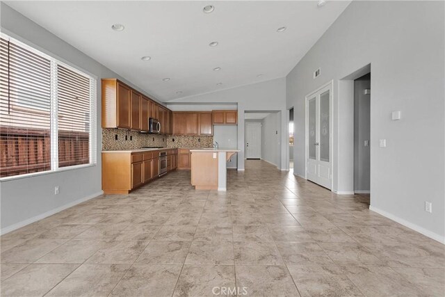 13204 Monrovia St, Hesperia, CA 92344 - kitchen with light countertops, appliances with stainless steel finishes, open floor plan, vaulted ceiling, and backsplash