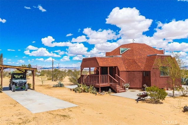 951 N Kuna Ave, Landers, CA 92285 - rear view of property featuring a shingled roof, a carport, and dirt driveway