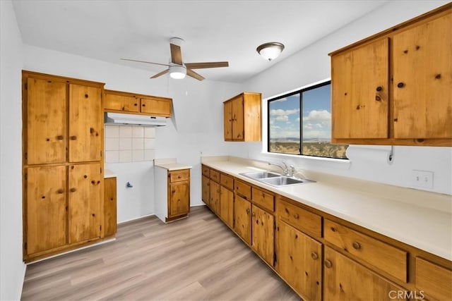 951 N Kuna Ave, Landers, CA 92285 - kitchen with brown cabinetry, ceiling fan, light wood-type flooring, light countertops, and under cabinet range hood