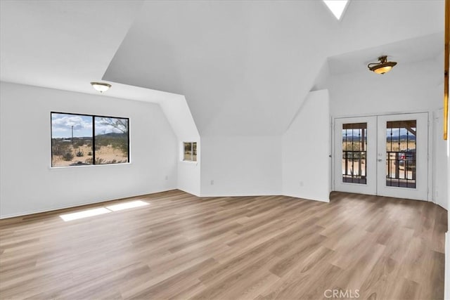 951 N Kuna Ave, Landers, CA 92285 - unfurnished living room with french doors, healthy amount of natural light, lofted ceiling, and light wood-type flooring