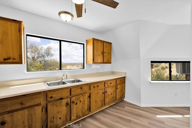 951 N Kuna Ave, Landers, CA 92285 - kitchen featuring a sink, brown cabinets, light countertops, ceiling fan, and light wood-style flooring