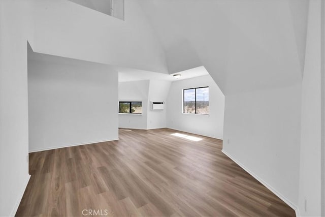 951 N Kuna Ave, Landers, CA 92285 - unfurnished living room featuring an AC wall unit, wood finished floors, and high vaulted ceiling