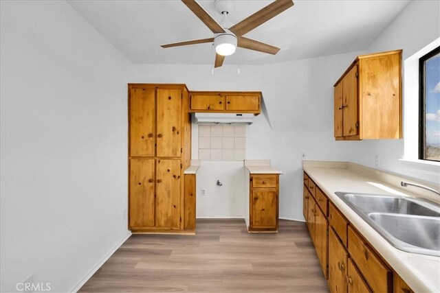 951 N Kuna Ave, Landers, CA 92285 - kitchen featuring a ceiling fan, a sink, brown cabinetry, and light wood finished floors