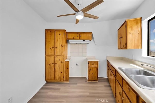 951 N Kuna Ave, Landers, CA 92285 - kitchen featuring a ceiling fan, brown cabinets, light wood-style floors, and light countertops