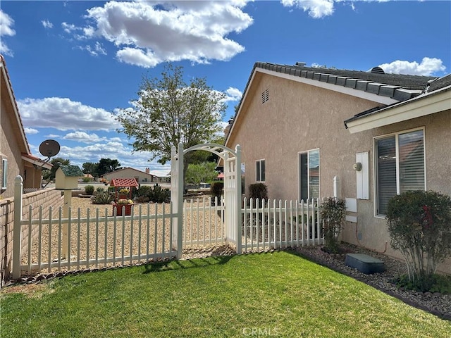 27813 Hummingbird Ln, Helendale, CA 92342 - view of home's exterior with stucco siding, fence, and a lawn