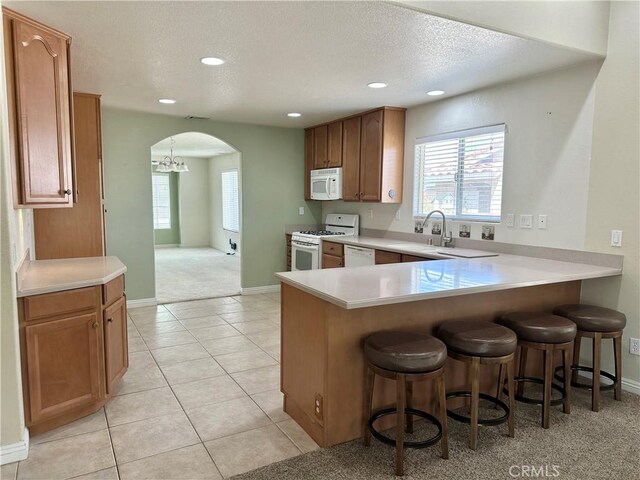 27813 Hummingbird Ln, Helendale, CA 92342 - kitchen featuring a textured ceiling, light countertops, white appliances, arched walkways, and a sink