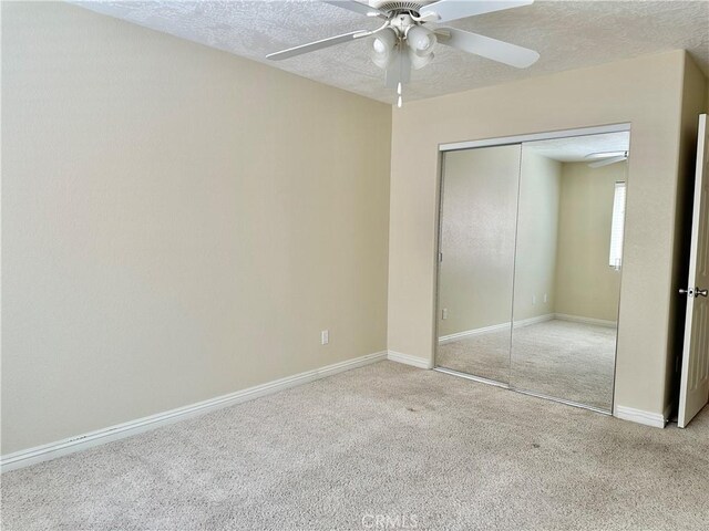27813 Hummingbird Ln, Helendale, CA 92342 - unfurnished bedroom featuring a closet, carpet flooring, a textured ceiling, baseboards, and a ceiling fan