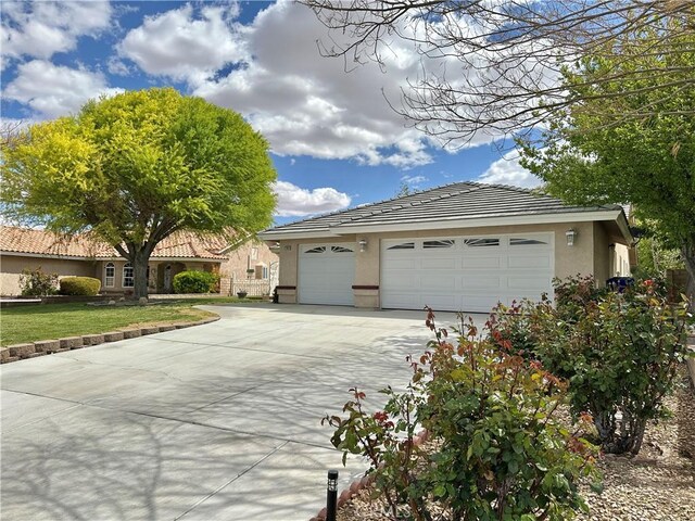 27813 Hummingbird Ln, Helendale, CA 92342 - view of front of home featuring an attached garage, concrete driveway, a tile roof, stucco siding, and an outdoor structure