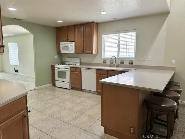 27813 Hummingbird Ln, Helendale, CA 92342 - kitchen featuring white appliances, a sink, arched walkways, visible vents, and a peninsula