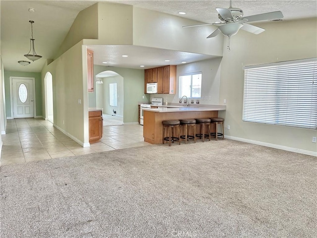 27813 Hummingbird Ln, Helendale, CA 92342 - kitchen with white appliances, a ceiling fan, light carpet, arched walkways, and light tile patterned floors