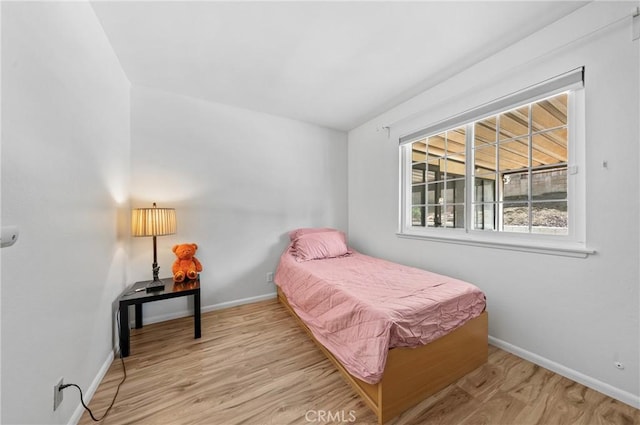 bedroom with baseboards and wood finished floors