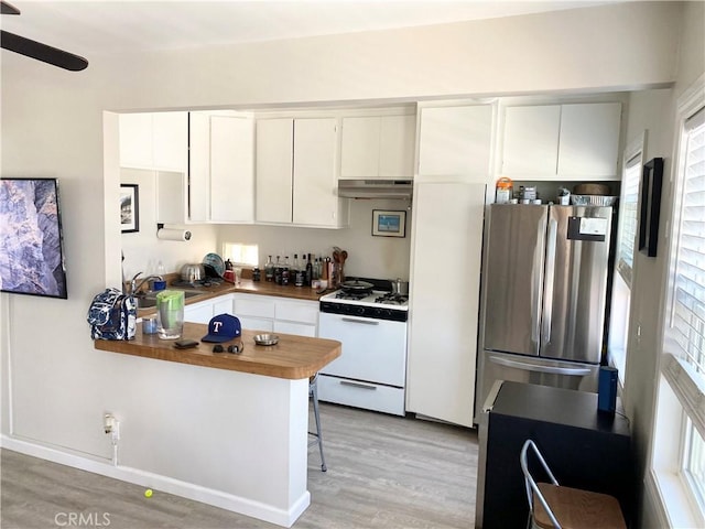 258 17th St, Seal Beach, CA 90740 - kitchen with a sink, freestanding refrigerator, under cabinet range hood, light wood finished floors, and white gas range oven
