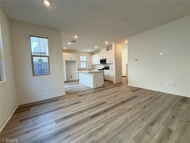 15903 Blue Copper Way, Fontana, CA 92336 - unfurnished living room with light wood finished floors, recessed lighting, baseboards, and a sink