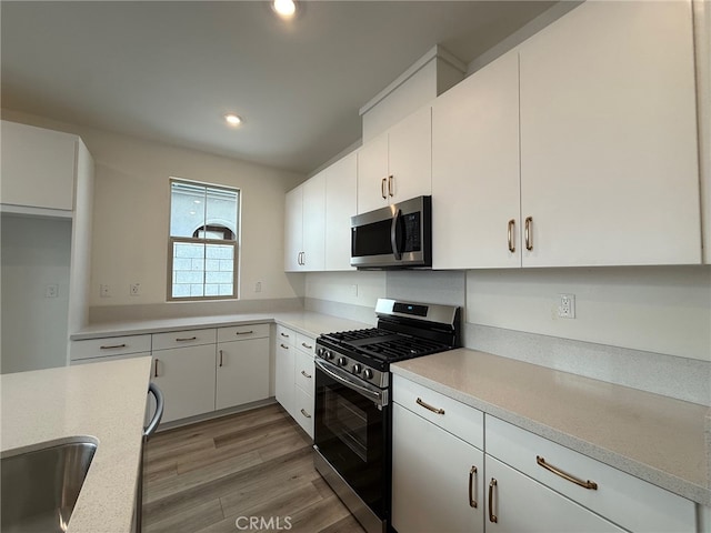 15903 Blue Copper Way, Fontana, CA 92336 - kitchen with appliances with stainless steel finishes, light countertops, white cabinets, recessed lighting, and light wood finished floors