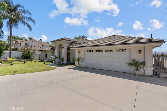 1403 Sonora St, San Bernardino, CA 92404 - view of front of property featuring a garage, concrete driveway, a tile roof, a front lawn, and stucco siding