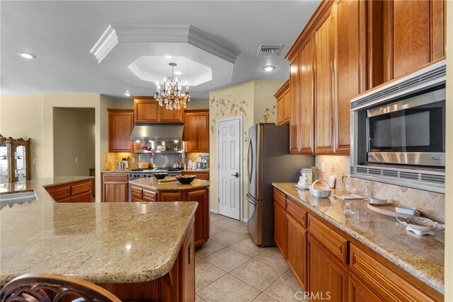 1403 Sonora St, San Bernardino, CA 92404 - kitchen with a notable chandelier, appliances with stainless steel finishes, a large island, under cabinet range hood, and visible vents