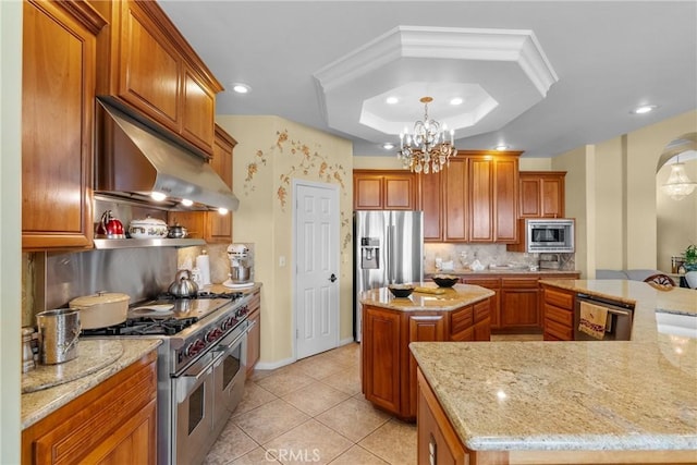 1403 Sonora St, San Bernardino, CA 92404 - kitchen with a center island, appliances with stainless steel finishes, brown cabinetry, and a tray ceiling