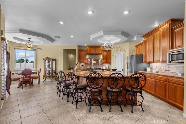 1403 Sonora St, San Bernardino, CA 92404 - kitchen featuring visible vents, tasteful backsplash, a kitchen bar, and appliances with stainless steel finishes
