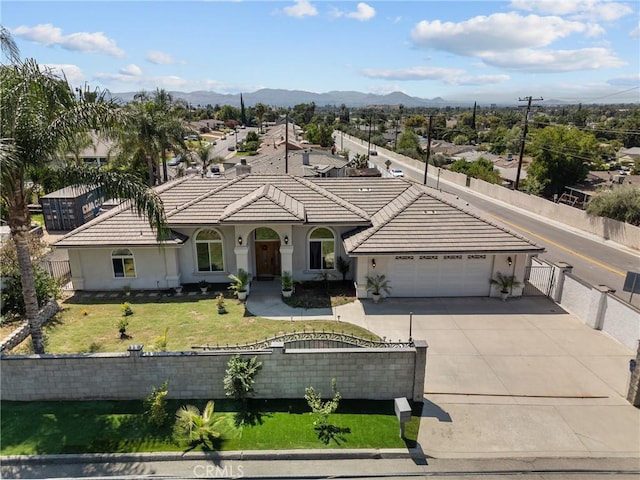 1403 Sonora St, San Bernardino, CA 92404 - view of front of house featuring a tile roof, a fenced front yard, a garage, and stucco siding