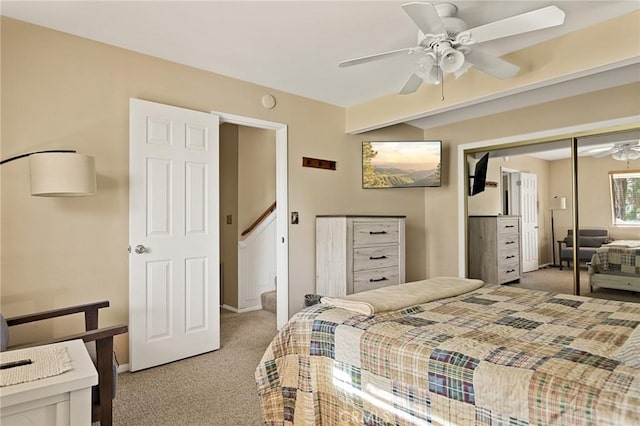 bedroom with light colored carpet, a closet, baseboards, and a ceiling fan