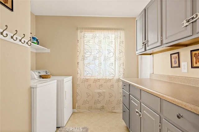 clothes washing area featuring washing machine and dryer, cabinet space, and light floors