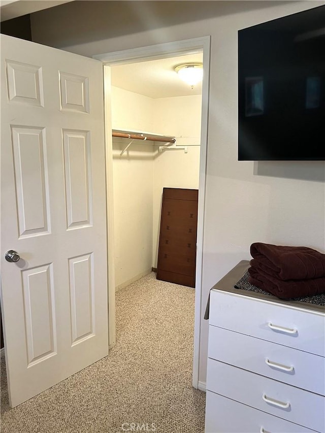 walk in closet featuring light carpet