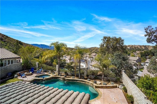 view of pool featuring a residential view, a mountain view, a patio area, a fenced backyard, and a pool with connected hot tub