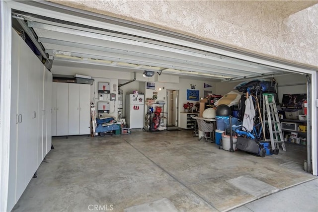 garage with freestanding refrigerator and a garage door opener