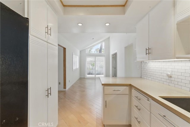 8292 Manifesto Cir, Huntington Beach, CA 92646 - kitchen with light countertops, a peninsula, light wood finished floors, decorative backsplash, and lofted ceiling
