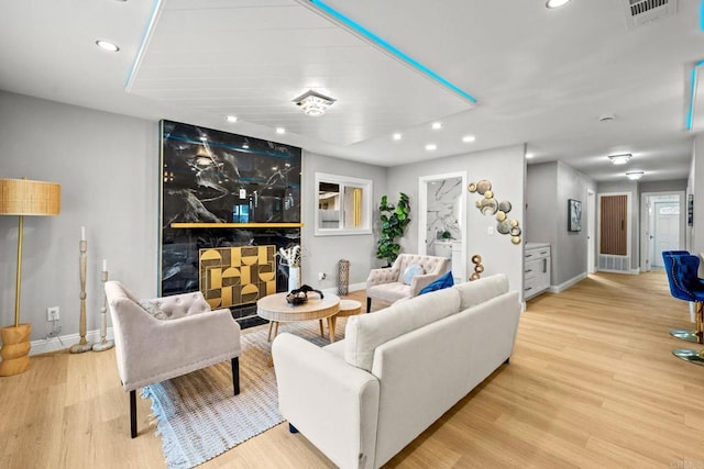 living area featuring baseboards, visible vents, wood finished floors, and recessed lighting