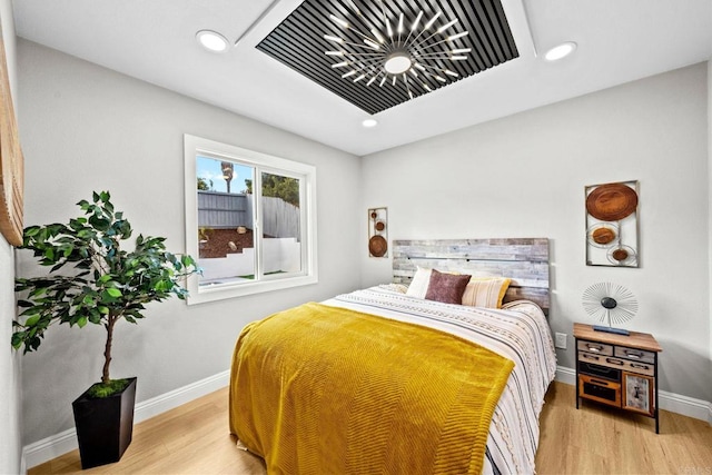 bedroom with baseboards, wood finished floors, and recessed lighting
