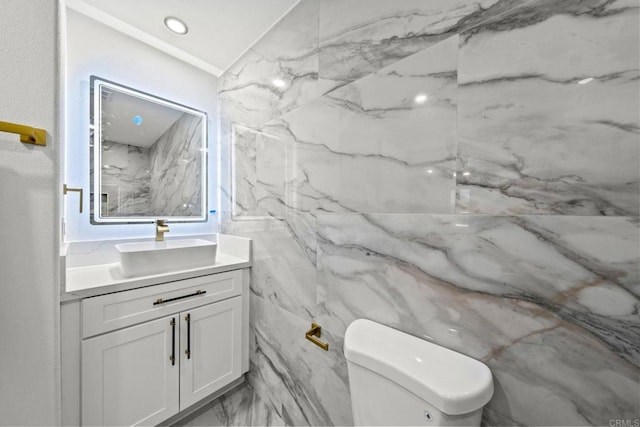 half bath featuring marble finish floor, vanity, toilet, and recessed lighting