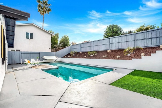 view of swimming pool with a patio, a fenced in pool, and a fenced backyard