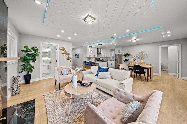 living room with light wood-style floors, baseboards, recessed lighting, and wood ceiling