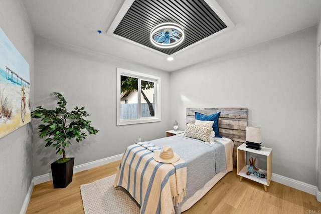 bedroom featuring visible vents, baseboards, and wood finished floors