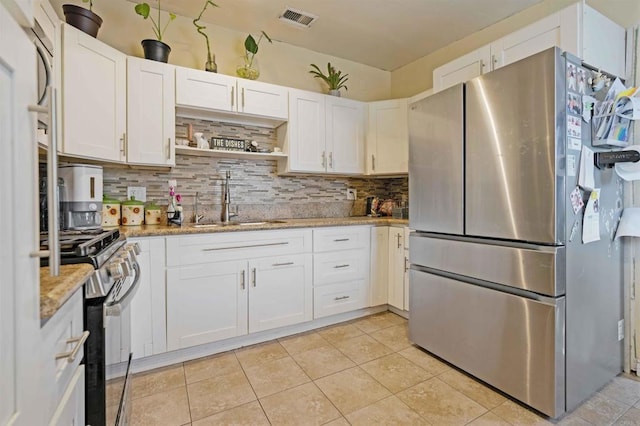804 S 37th St, San Diego, CA 92113 - kitchen with appliances with stainless steel finishes, decorative backsplash, white cabinetry, and light stone countertops