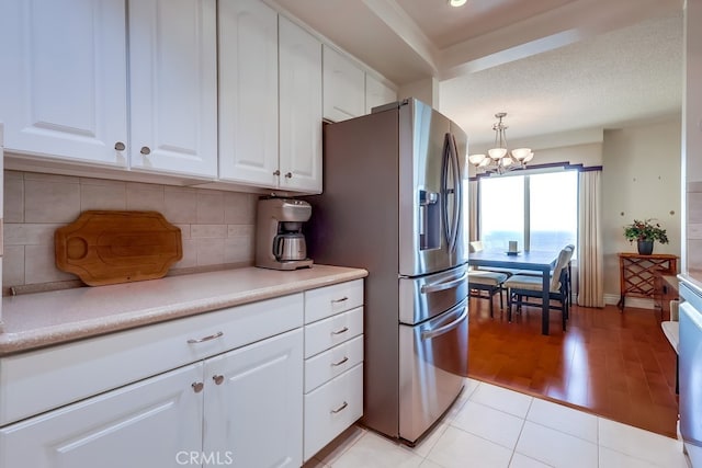 3200 La Rotonda Dr Unit 316, Rancho Palos Verdes, CA 90275 - kitchen featuring a notable chandelier, stainless steel fridge, light tile patterned floors, light countertops, and decorative backsplash