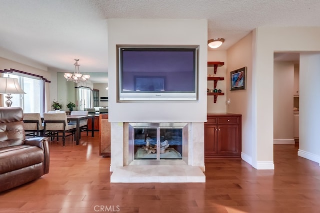 3200 La Rotonda Dr Unit 316, Rancho Palos Verdes, CA 90275 - living room with baseboards, an inviting chandelier, wood finished floors, and a textured ceiling