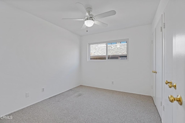 empty room with light colored carpet, ceiling fan, and baseboards