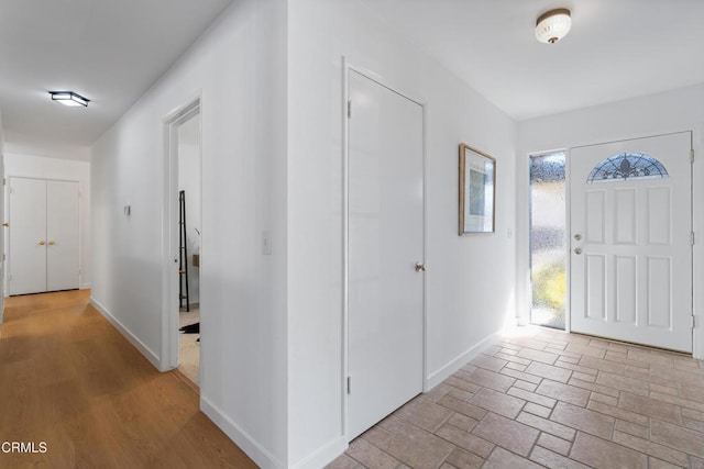 foyer featuring baseboards and stone finish flooring