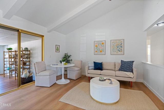living room featuring vaulted ceiling with beams, wood finished floors, and baseboards