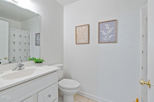 bathroom featuring tile patterned floors, toilet, baseboards, and vanity