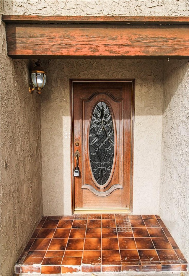 entrance to property featuring stucco siding
