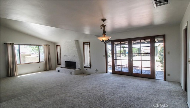 unfurnished living room with visible vents, a large fireplace, carpet floors, and french doors